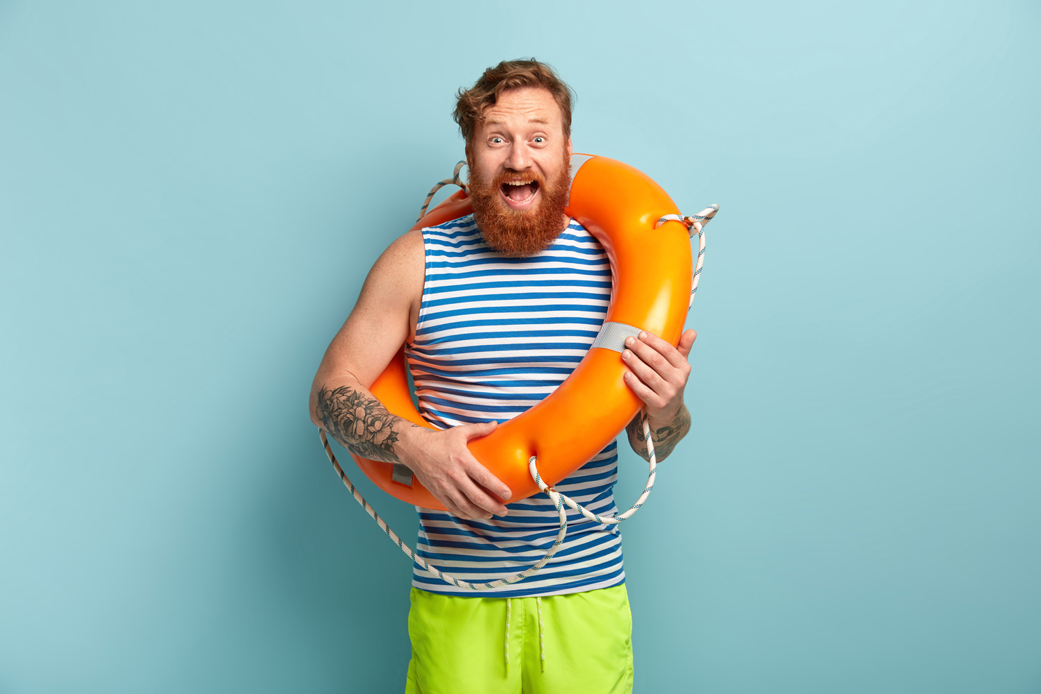 Jeune homme en marinière et maillot de bain avec une bouée autour du cou. Fusion Intérim ne vous laisse pas livré à vous même et vous aide à éviter la noyade avec un entretien d'embauche bien préparé.