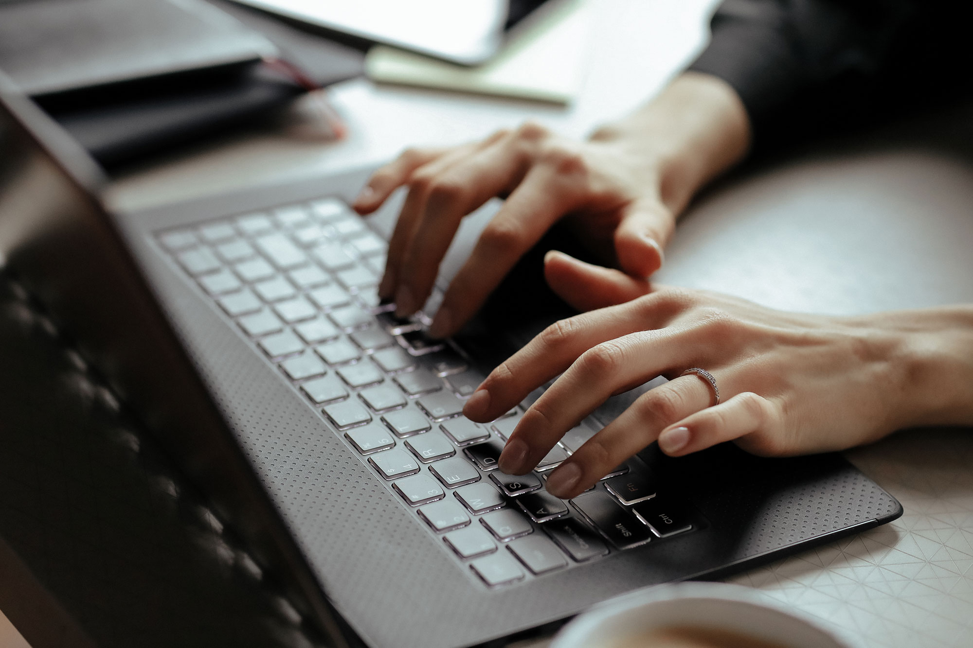 Gros plan sur les mains d'une personne tapant sur un clavier d'ordinateur portable. Outils de gestion dématérialisés de Fusion Intérim Limoges.